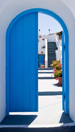 Intérieur méditerranéen inspiré de la Grèce avec murs blancs, touches de bleu profond et matières naturelles.